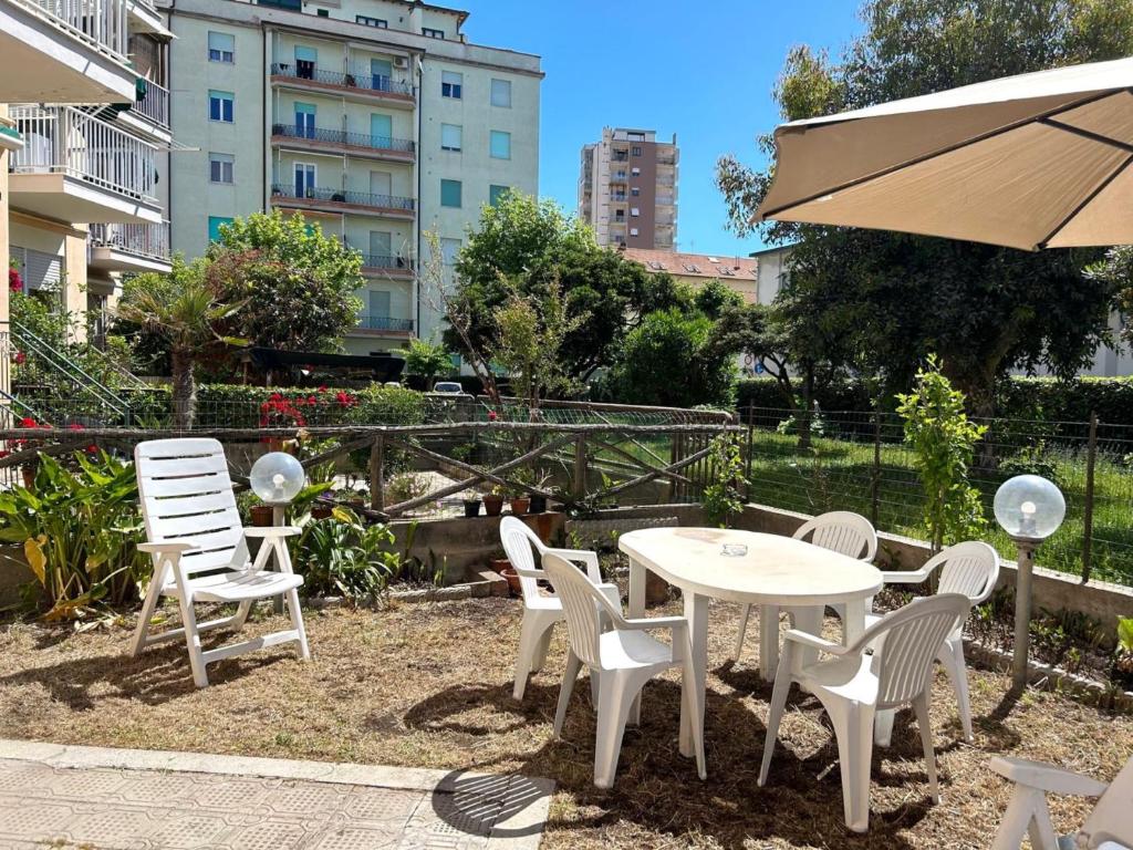 a white table and chairs and an umbrella at Appartamento TD in Follonica