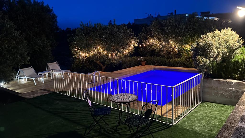 a bird cage with a swimming pool at night at Lamia Pieranna in Cisternino