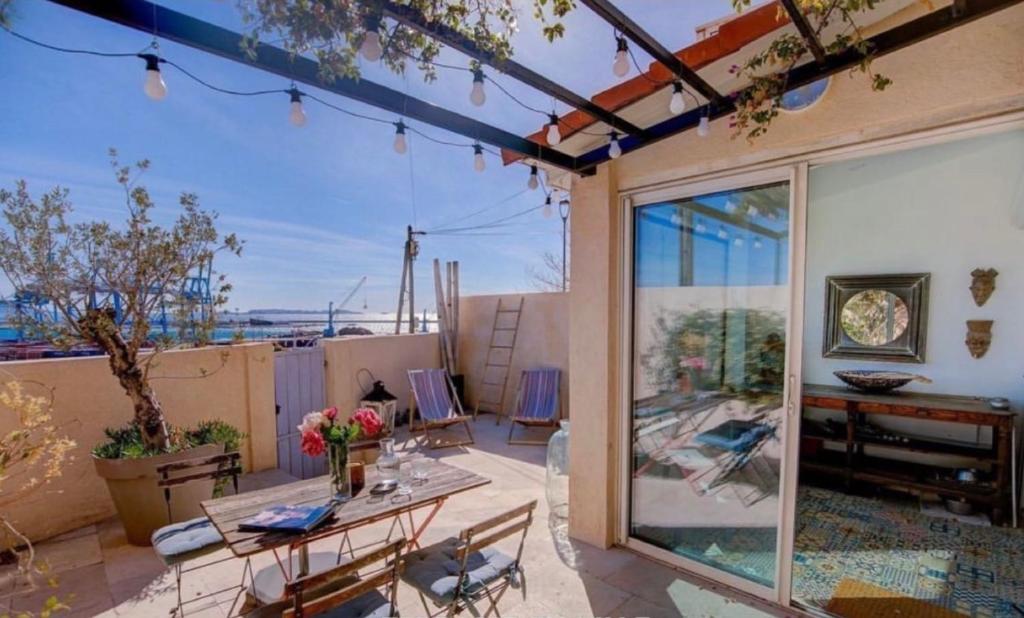 d'une terrasse avec une table et une vue sur l'océan. dans l'établissement Maison vue Mer, Marseille., à Marseille