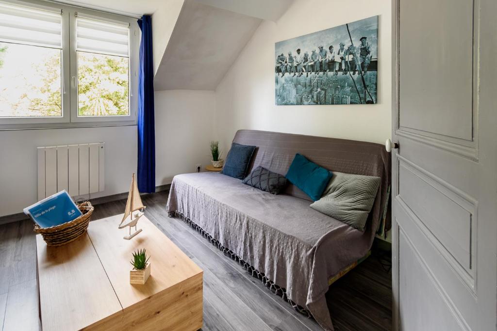 ein Wohnzimmer mit einer Couch und einem Fenster in der Unterkunft Villa de la plage in Saint-Brevin-les-Pins