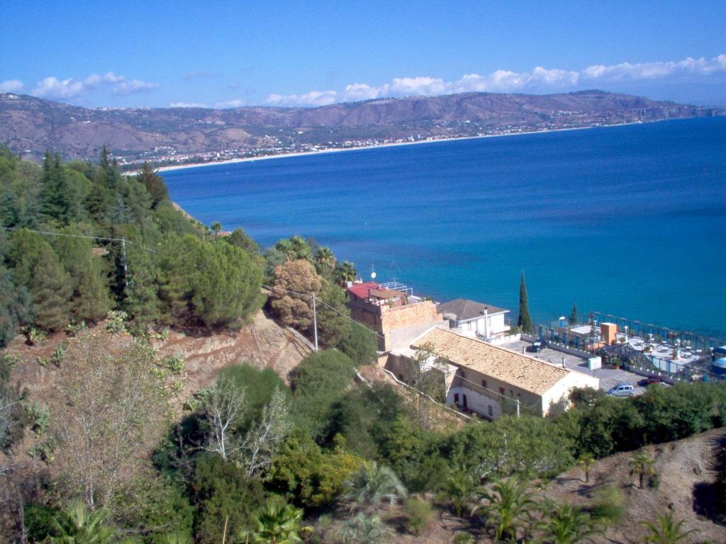 a town on a hill next to a body of water at Il Nocchiero City Hotel in Soverato Marina