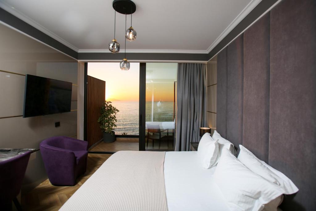 a bedroom with a bed and a view of the ocean at Belvedere Hotel in Vlorë
