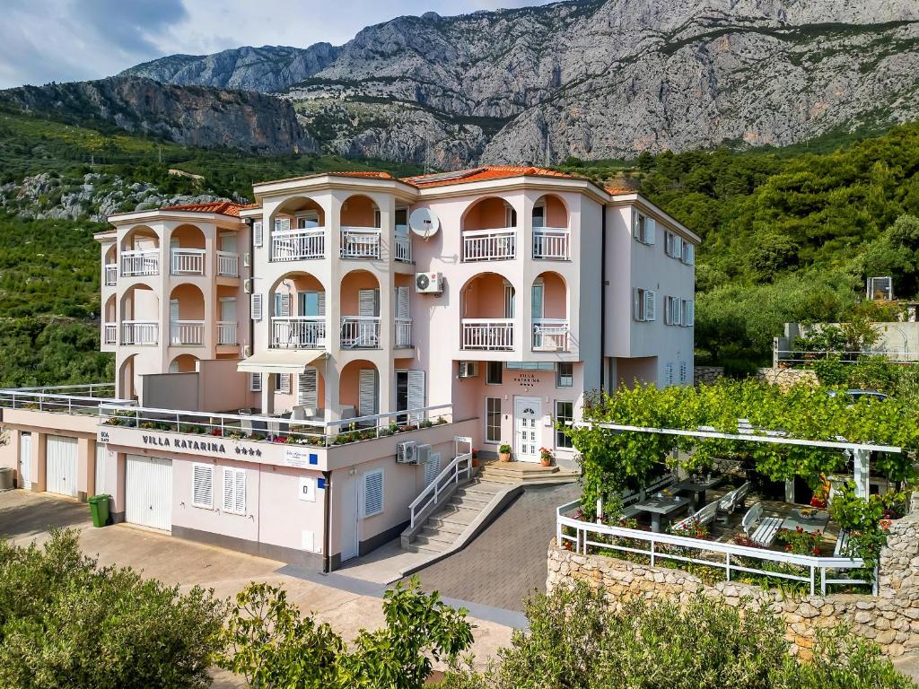 an apartment building with a mountain in the background at Apartments Villa Katarina in Tučepi
