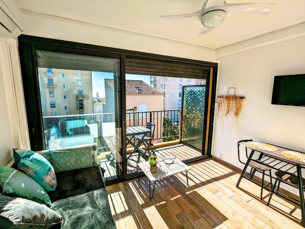 d'un salon avec un canapé et un balcon. dans l'établissement Charmant studio calme et climatisé, près de la plage, à Canet en Roussillon, à Canet