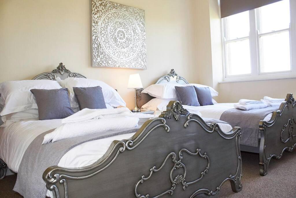 two beds in a bedroom with two bedsitures at The Palm Suite in Southport