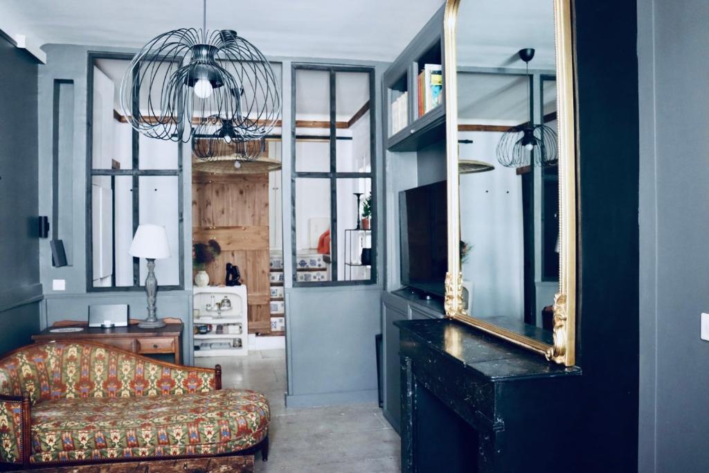 een woonkamer met een bank en een spiegel bij Casa Cabanel in Montpellier