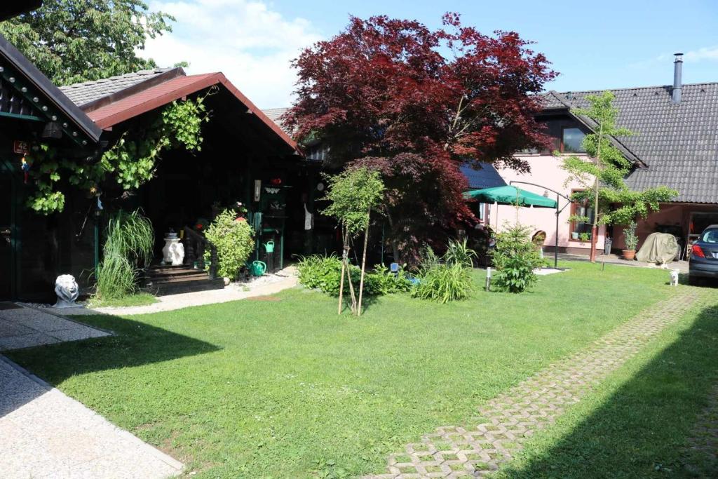 uma casa com um relvado em frente a uma casa em Frenk cottage 5 KM FROM THE AIRPORT-free transportation em Šenčur
