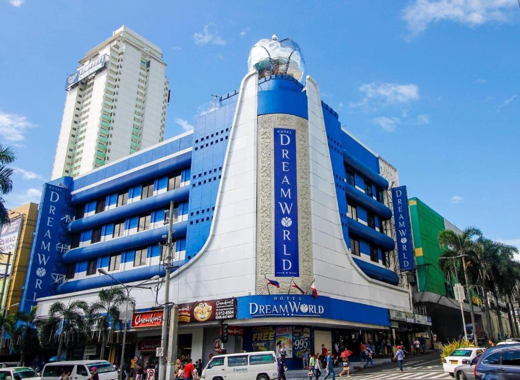 un edificio en una calle de la ciudad con coches en la calle en Hotel Dream World Araneta Cubao, en Manila
