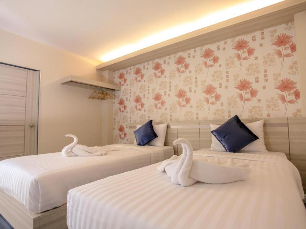Dos camas con cisnes en una habitación en Klang Muang @ Nongkhai Hotel, en Nong Khai
