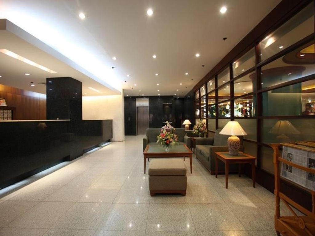 a lobby with a couch and a table in a building at Sunny Bay Suites in Manila