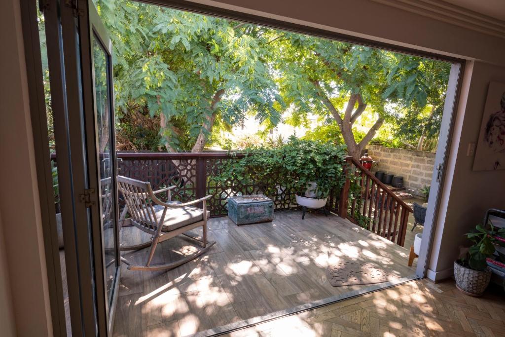 einen Balkon mit einem Stuhl und einem Baum in der Unterkunft Lillys Cottage Heritage House South Fremantle in South Fremantle