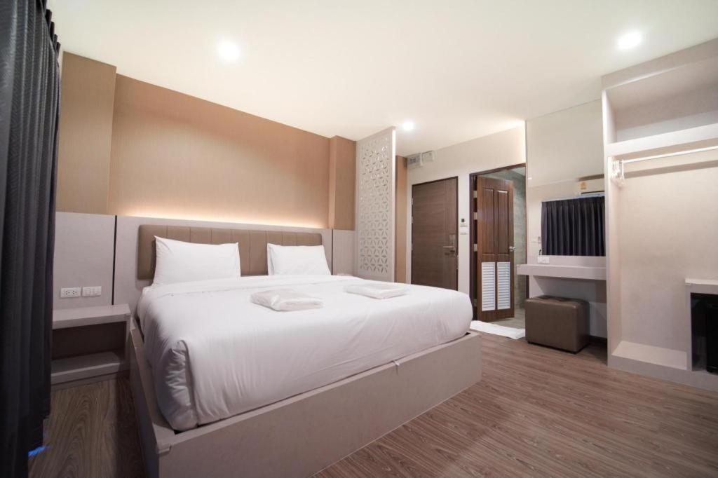a bedroom with a large white bed and a fireplace at The Y House in Chiang Mai