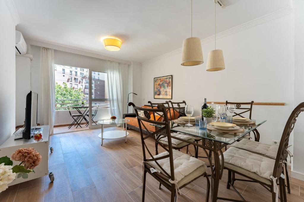 - une salle à manger et un salon avec une table et des chaises dans l'établissement MalagaSuite Malagueta Beach & Sun, à Malaga