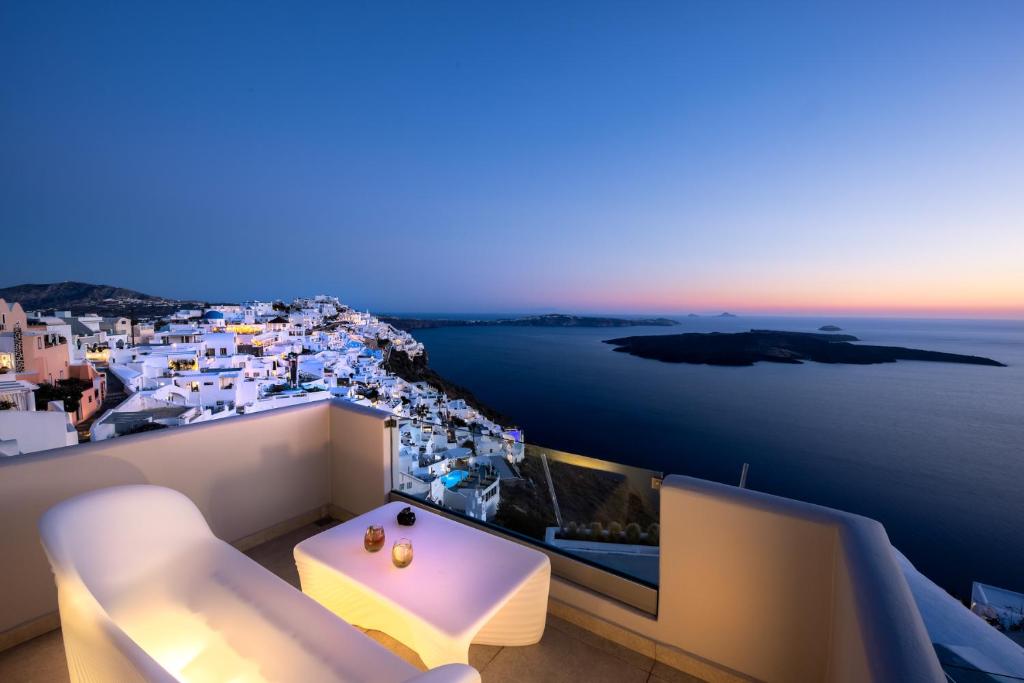 a balcony with a view of a city and the ocean at Damigos Caldera World in Firostefani
