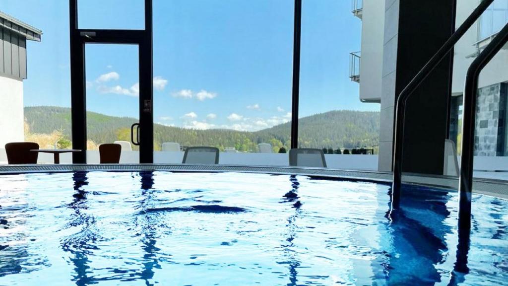 Biała Woda的住宿－Panorama - Czarna Góra Resort by Sun & Snow z nielimitowanym basenem，建筑物屋顶上的游泳池