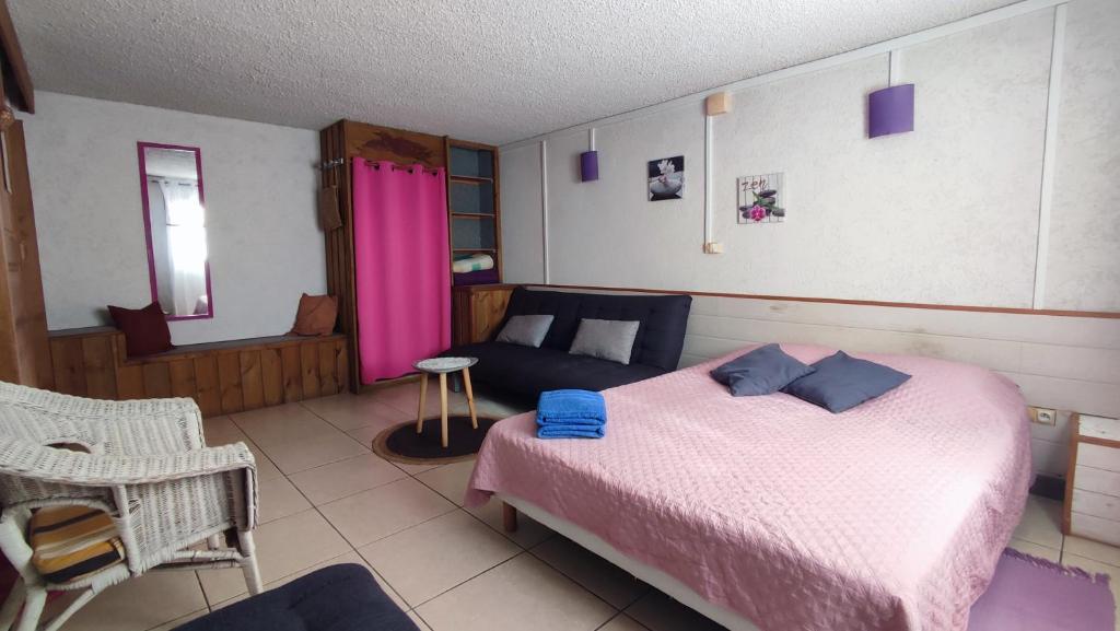 1 dormitorio con 1 cama y 1 sofá en Chez Nadine & Patrick, en Saint-Paul