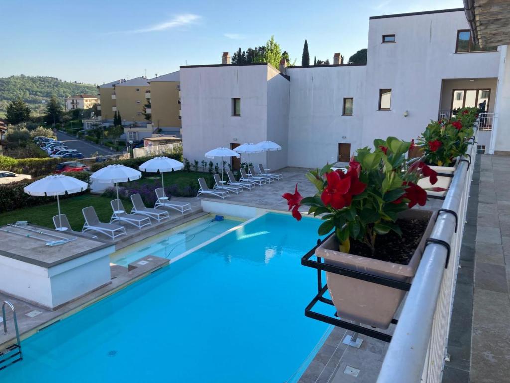 The Florence Hills Resort & Wellness في Pelago: مسبح الفندق مع الكراسي والمظلات