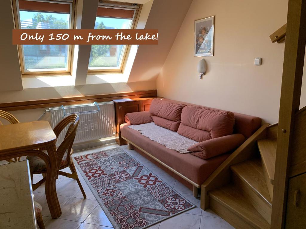 - un salon avec un canapé et une table dans l'établissement Lakeside Apartman Hévíz, à Hévíz