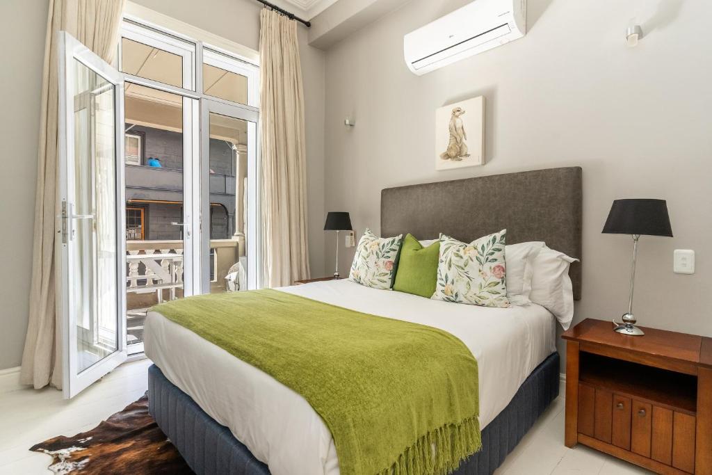 a bedroom with a large bed with a green blanket at Long Street Boutique Hotel in Cape Town