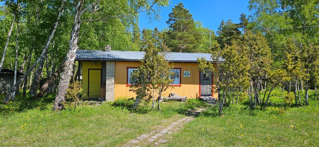 ein kleines gelbes und orangefarbenes Haus im Wald in der Unterkunft Trammi Maja 