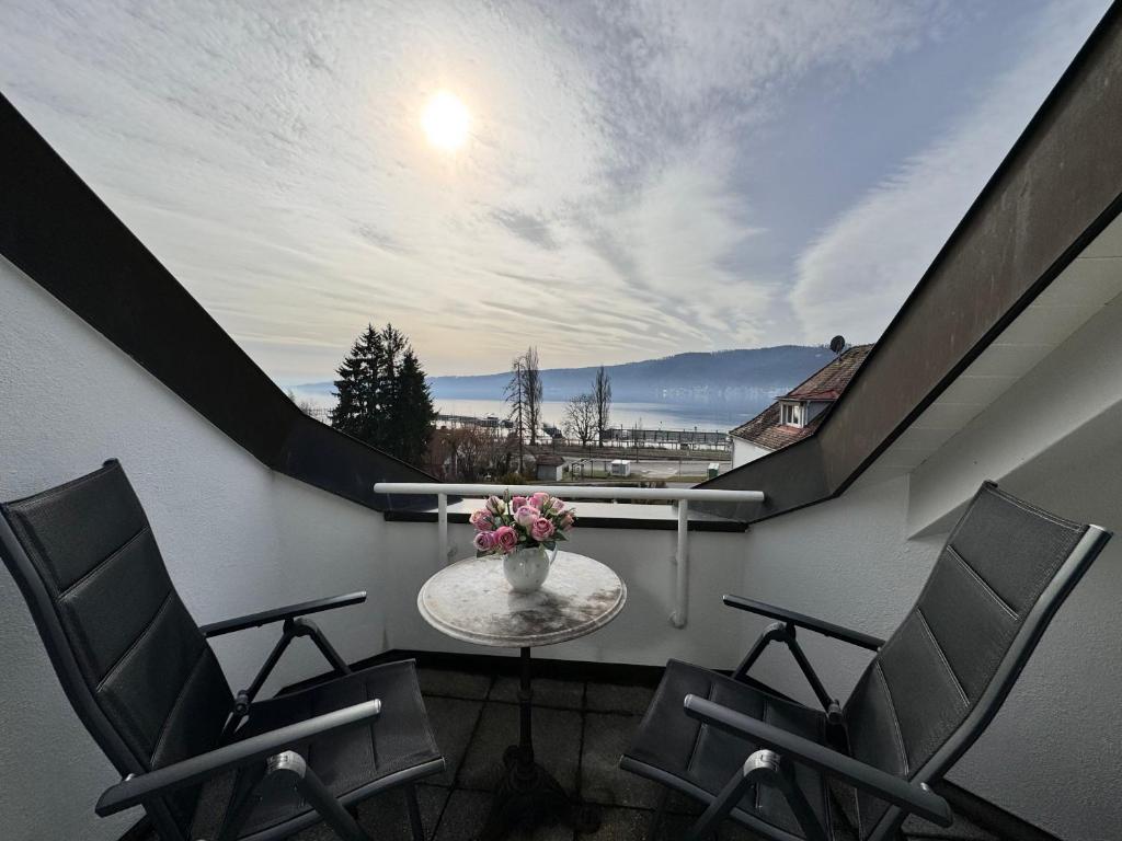 a balcony with chairs and a table with flowers on it at Casa Via Bodman-Ludwigshafen in Bodman-Ludwigshafen