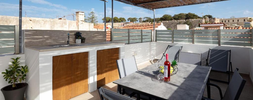 een balkon met een tafel en een wastafel op een dak bij Ebenus Residence in Rethimnon