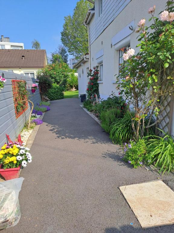 una entrada de una casa con flores en un patio en Gîtes Les Lucioles, en Mont-Saint-Aignan