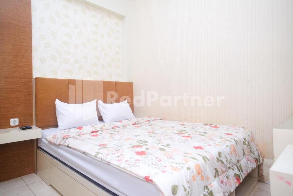 1 Schlafzimmer mit einem Bett mit Blumendecke in der Unterkunft Tatti Inn Syariah Seturan RedPartner in Yogyakarta