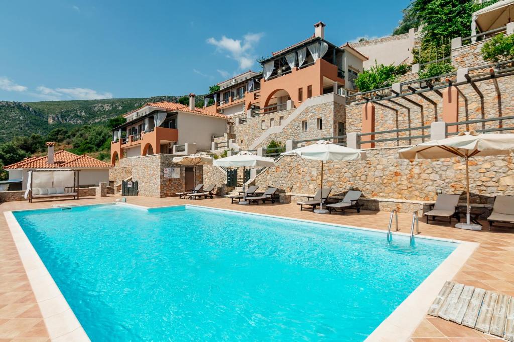 a villa with a swimming pool in front of a building at Apelon Tiritas Villas in Leonidion