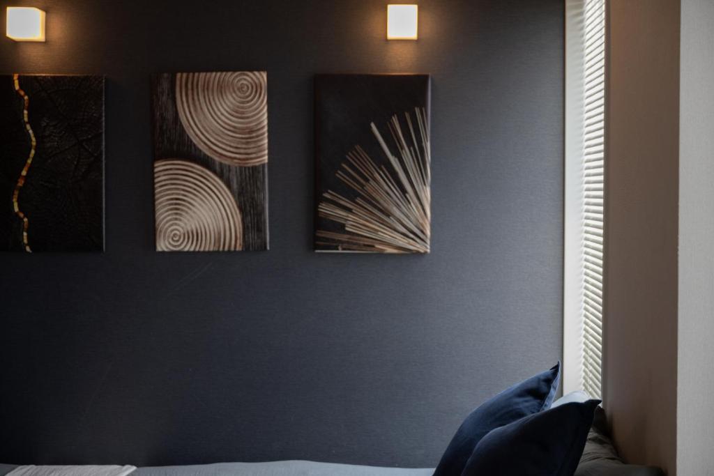 three pieces of art hanging on a wall at Hotel SERA LUNA -ホテル セラルナ- in Naha