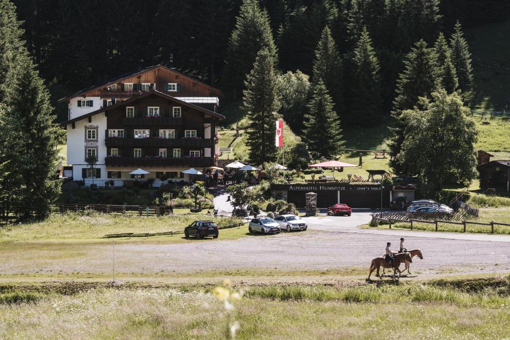 a person riding a horse in front of a house at Alpenhotel Heimspitze in Gargellen