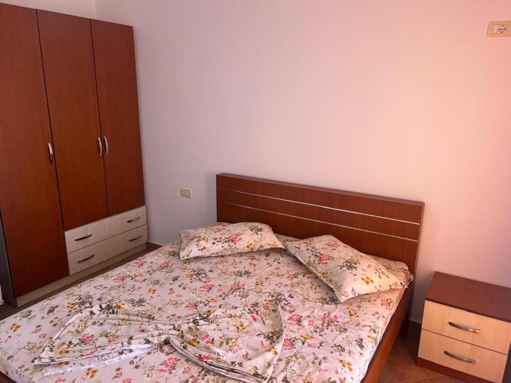 a bedroom with a bed with a wooden headboard at Apartamente ne Shengjin in Shëngjin