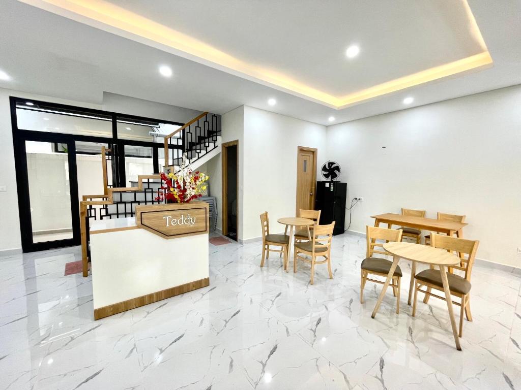 a lobby with tables and chairs and a restaurant at Teddy 96 Homestay & Cafe-3 stars-Grand World Phu Quoc in Phu Quoc