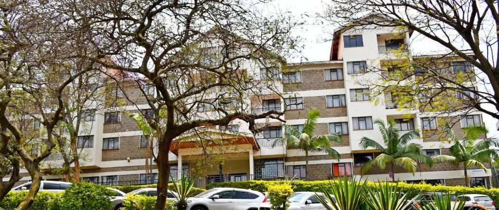 un gran edificio con coches estacionados frente a él en YWCA Parkview Suites, en Nairobi