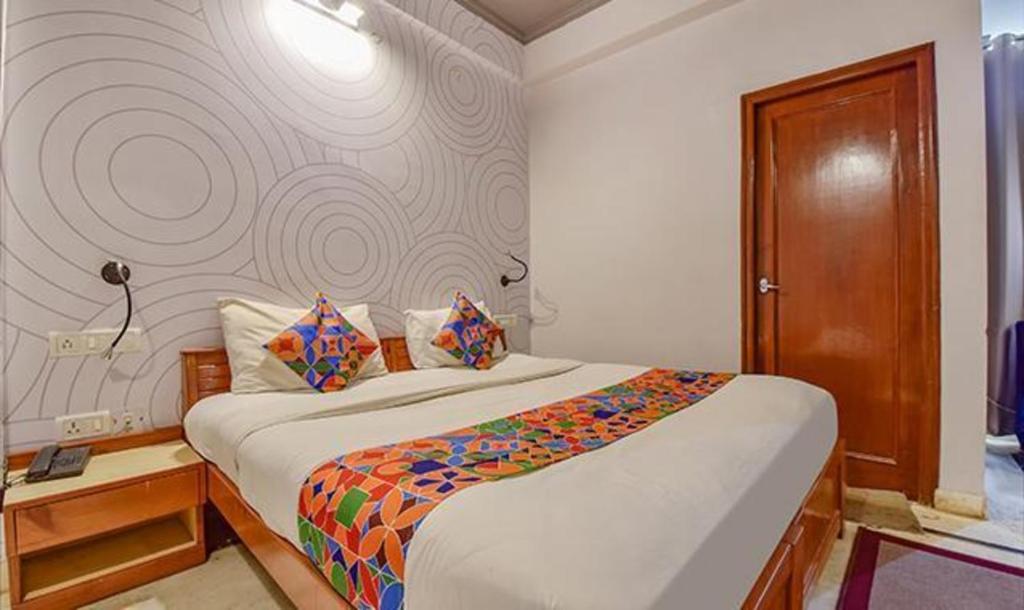 um quarto com uma cama grande e uma parede em FabHotel Shekhawati Palace em Jaipur