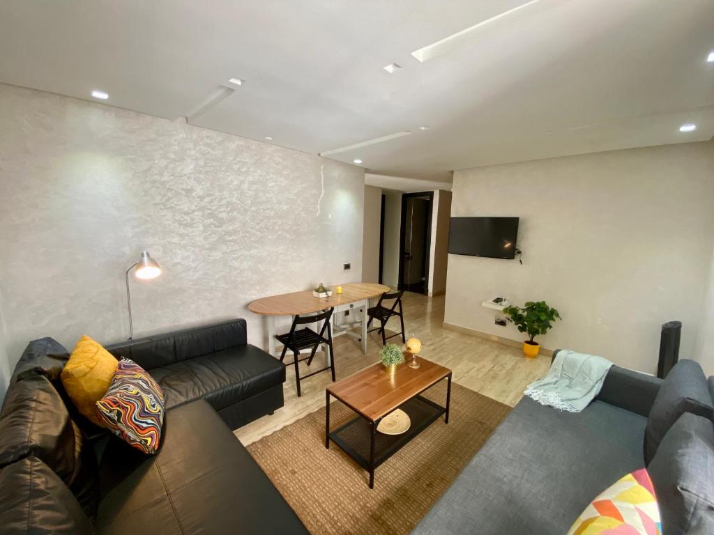 een woonkamer met een bank en een tafel bij Superbe appartement très bien situé in Casablanca