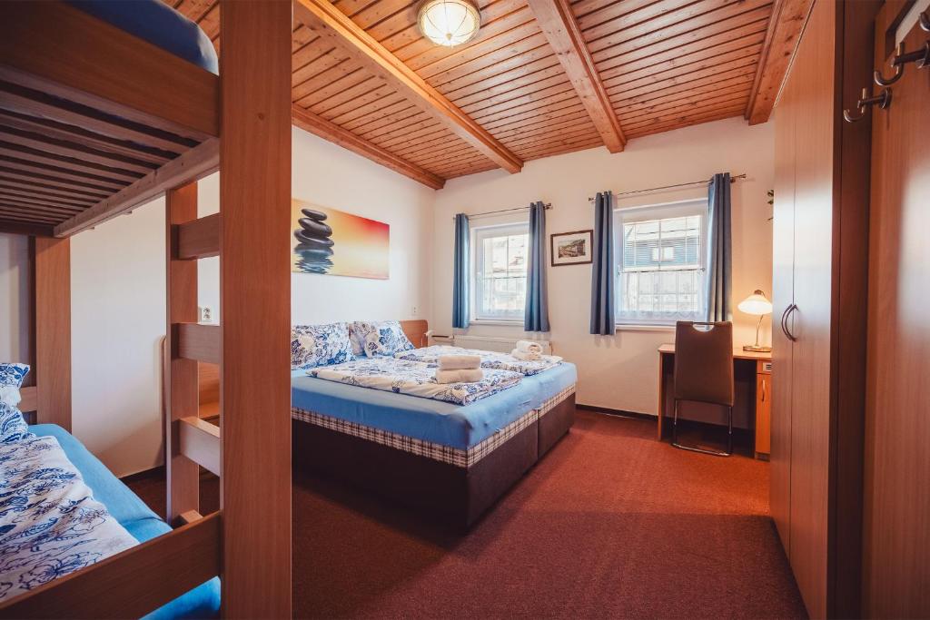 um quarto com um beliche, uma secretária e uma mesa em Chata Adélka em Boží Dar