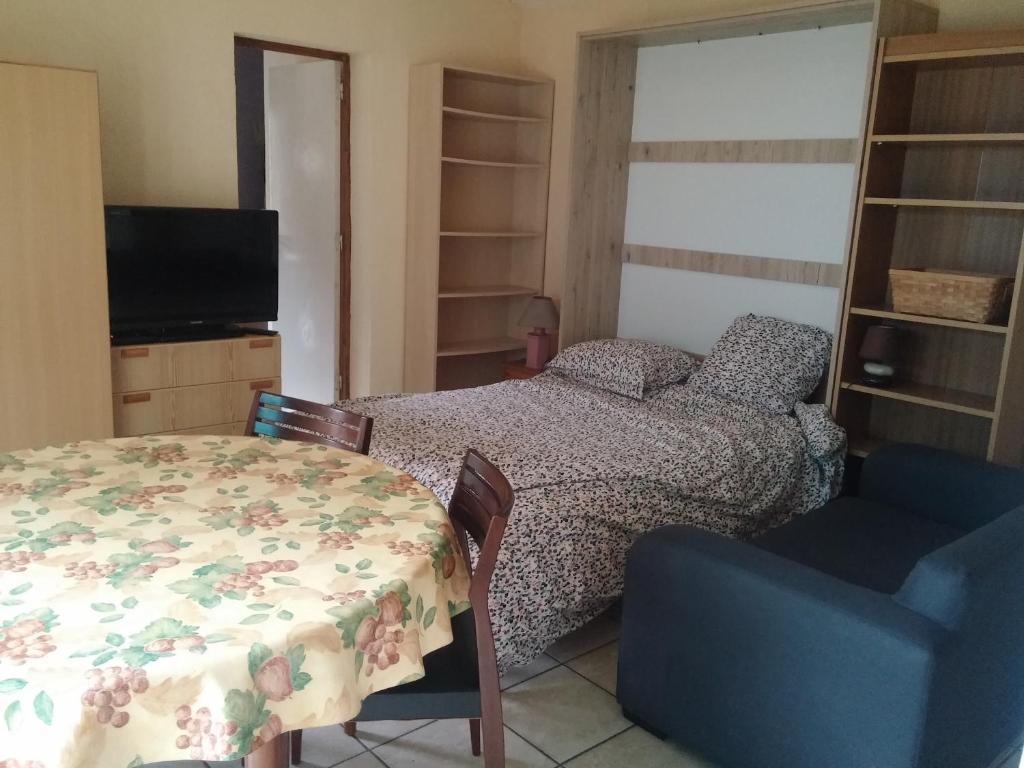 une chambre avec un lit, une table et une chaise dans l'établissement T1 47m2 + Jardin 60m2, à La Teste-de-Buch