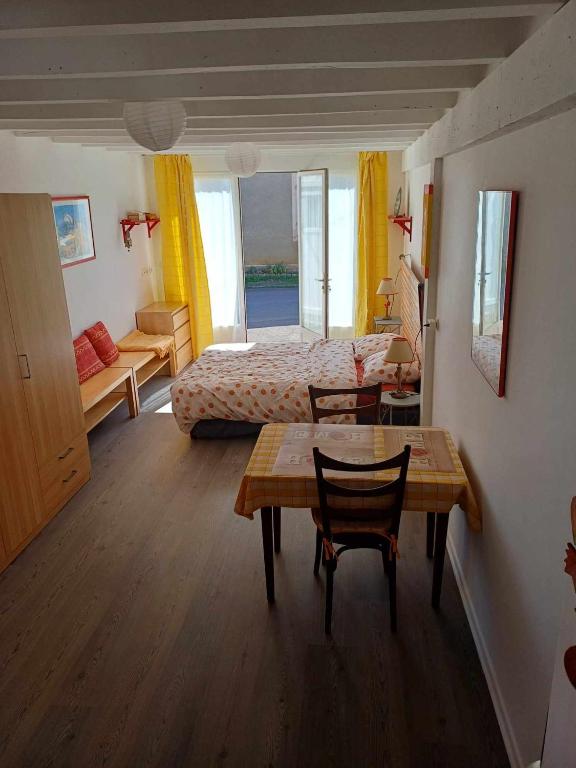 une chambre avec un lit, une table et des chaises dans l'établissement Studio meublé, à Antigny-la-Ville