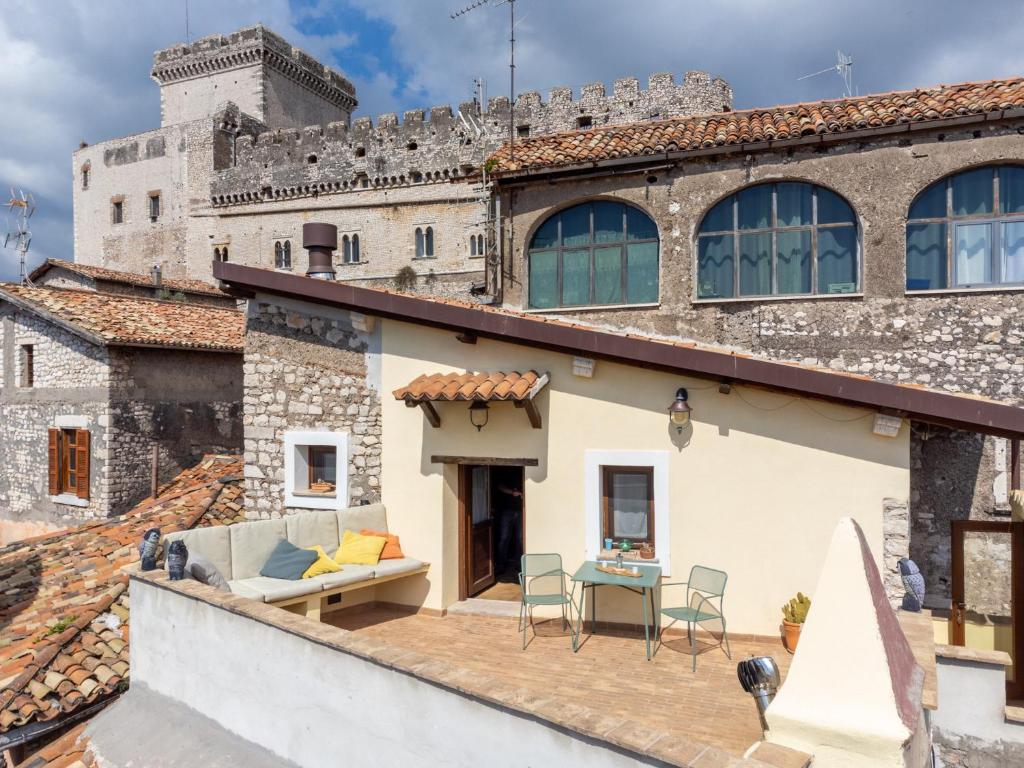 une maison avec une terrasse en face d'un bâtiment dans l'établissement Aurora Medieval House, à Sermoneta