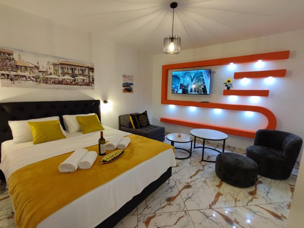 een hotelkamer met een groot bed en stoelen bij Melograno in Tivat