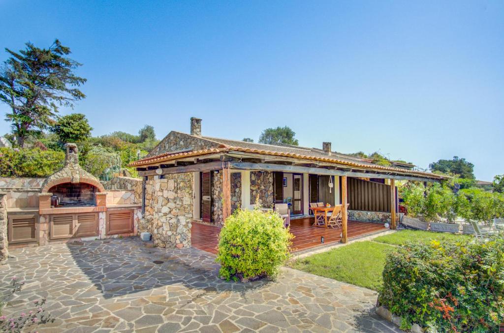 a stone house with a porch and a patio at VILLA MARIA - CAPO D'ORSO - HOME and MORE in Palau