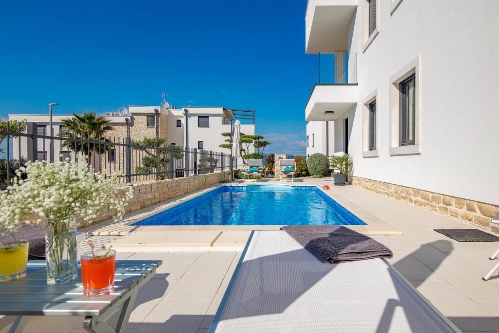 a swimming pool in the backyard of a house at Luxury apartment Hyperion with private pool and garden in Murter