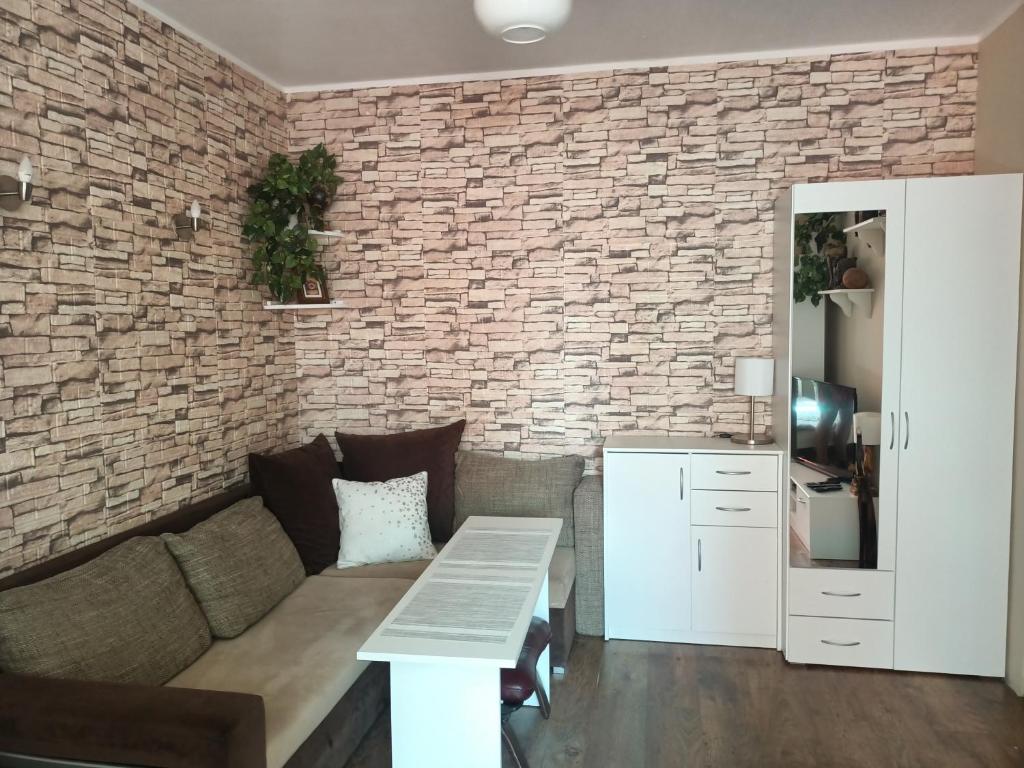 a living room with a couch and a brick wall at Atrakcyjne Matejki in Świnoujście