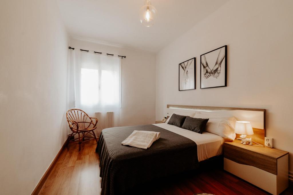 een slaapkamer met een bed en een bureau met een stoel bij Apartamento Juzgados in Logroño
