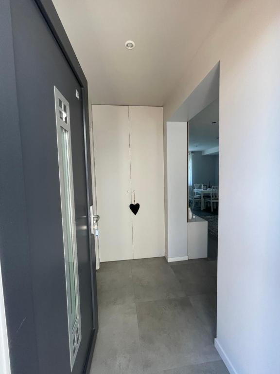 einen Flur mit Tür mit Herz an der Wand in der Unterkunft Apartment 4 confort&modern in Arad