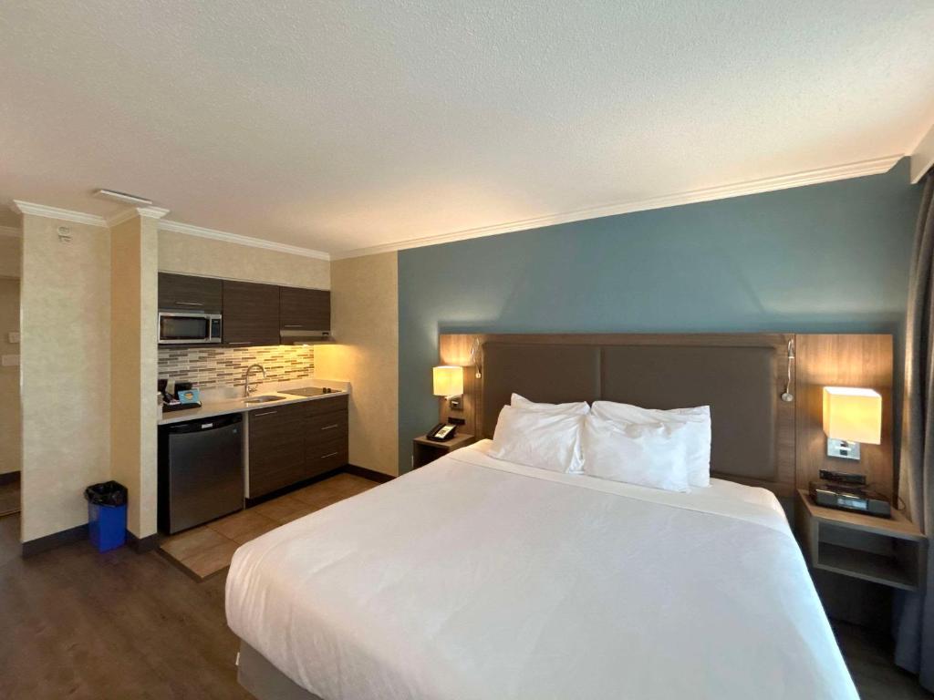 a hotel room with a large bed and a kitchen at Grand Park Hotel & Suites Downtown Vancouver, Ascend Hotel Collection in Vancouver