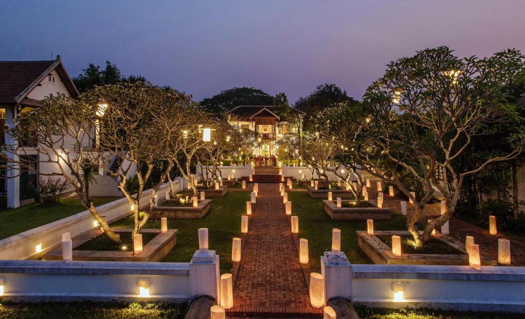 a garden with trees and lights at night at The Grand Luang Prabang, Affiliated by Meliá in Luang Prabang