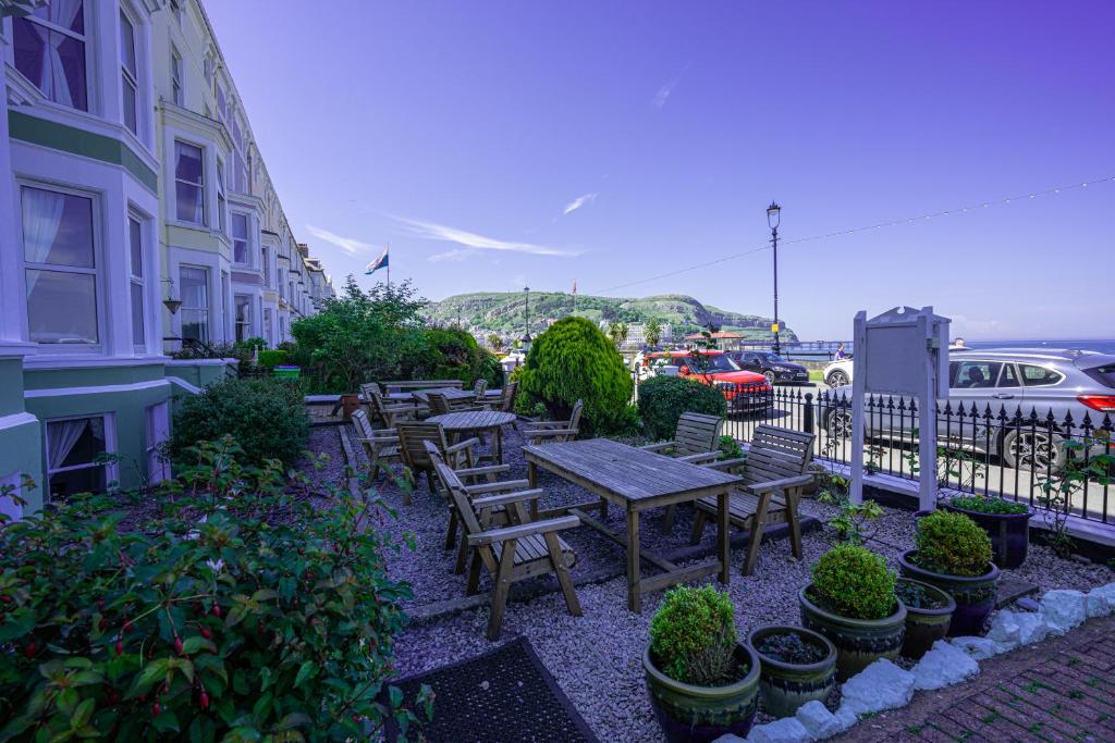 a picnic table and benches next to a building at The Central Hotel in Llandudno