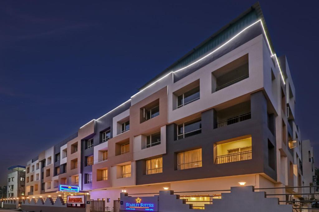 a large white building with lights on it at night at Starlit Suites Newtown Kolkata in kolkata